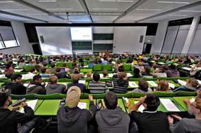 Students sit in a lecture hall in the seminar building at the Campus North.